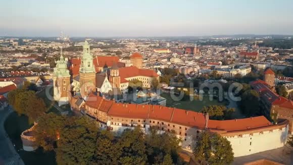 波兰克拉科夫皇家瓦维尔大教堂和城堡的鸟瞰图日落时有维斯图拉河公园庭院和游客视频的预览图