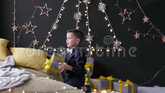 男孩把圣诞礼物放在圣诞景色的背景上视频的预览图