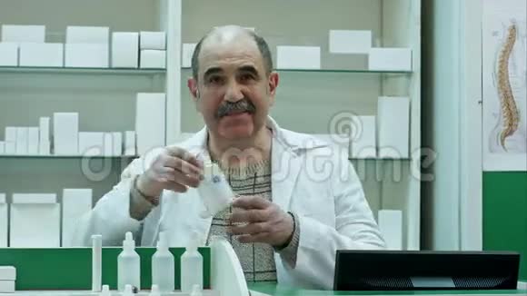 微笑的医生拿着一瓶白色空白标签的药片或药片来治疗疾病并期待着视频的预览图
