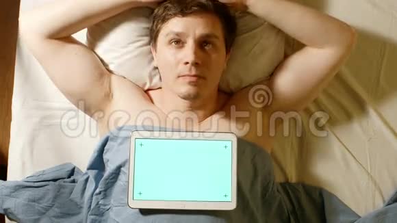 白人年轻人睡觉一台平板电脑放在他身上绿色屏幕视频的预览图