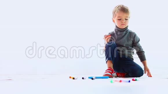 小男孩在地板上用彩色记号笔画图画视频的预览图