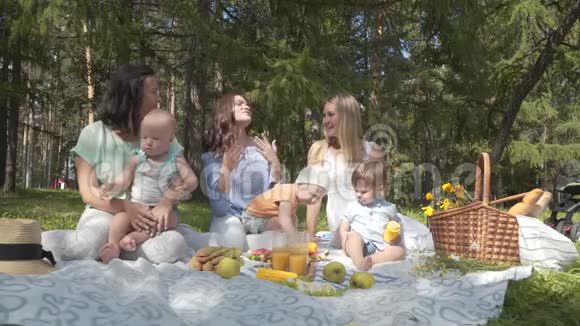 露营朋友在绿色草坪上野餐孩子在新鲜空气中视频的预览图