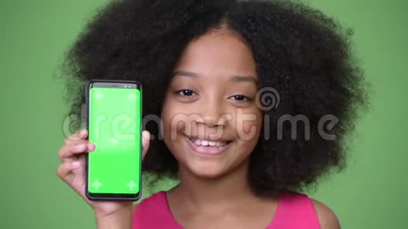 年轻可爱的非洲女孩非洲发型带着手机视频的预览图
