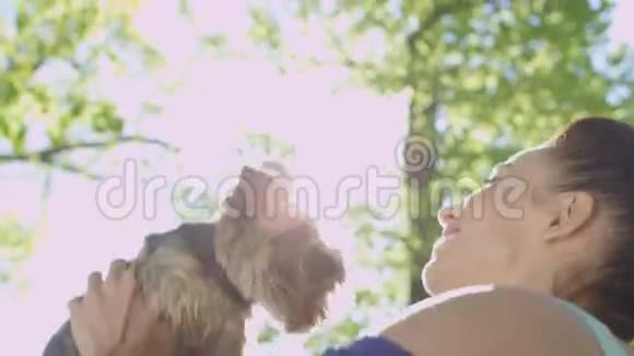年轻的笑女把她的狗吐出来的肖像视频的预览图