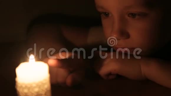 那男孩触摸燃烧的蜡烛的蜡视频的预览图