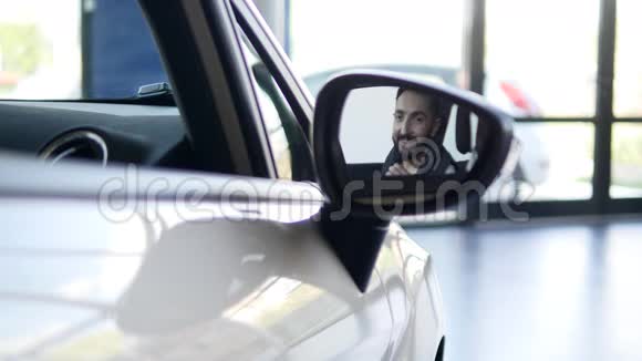 酷笑的快乐男人在镜子里展示钥匙车视频的预览图