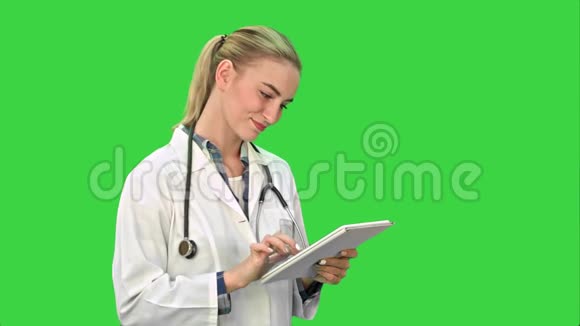 迷人的女医生听诊器微笑同时使用平板电脑在绿色屏幕Chroma键视频的预览图
