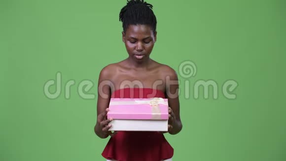 年轻漂亮的非洲女人打开礼品盒视频的预览图