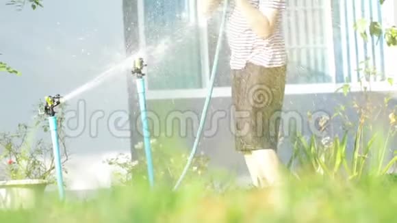 4在一个阳光明媚的炎热日子里一个男孩手持亚洲男孩正在玩水非常喜欢用水洗澡视频的预览图