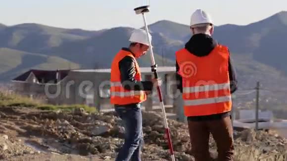 两名测量员在山顶进行测地测量视频的预览图