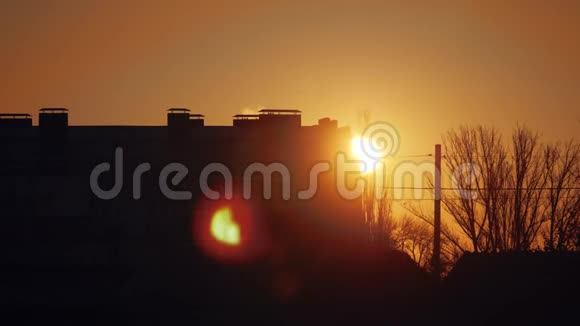 日落时城市景观轮廓多层建筑清晨黎明太阳从屋后向外望视频的预览图