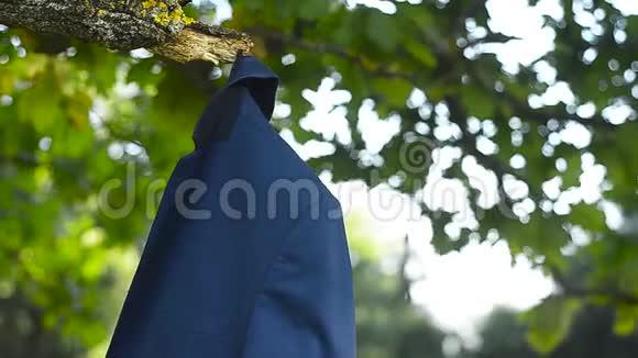男子套装挂在公园的树枝上视频的预览图
