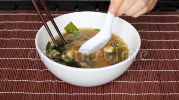 双手用勺子搅拌米索汤用排骨拣豆腐视频的预览图