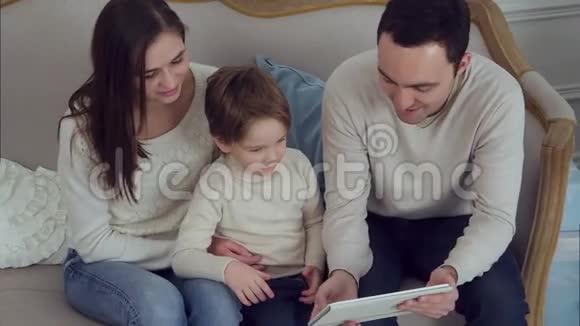 三个幸福的家庭在平板电脑上观看有趣的视频视频的预览图