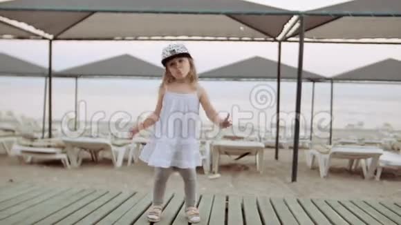 傍晚小女孩在鹅卵石海滩跳舞背景是大海视频的预览图
