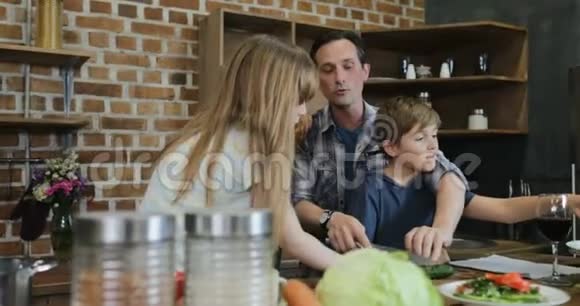 两个孩子在家准备食物在家谈话切肉时的家庭交流视频的预览图