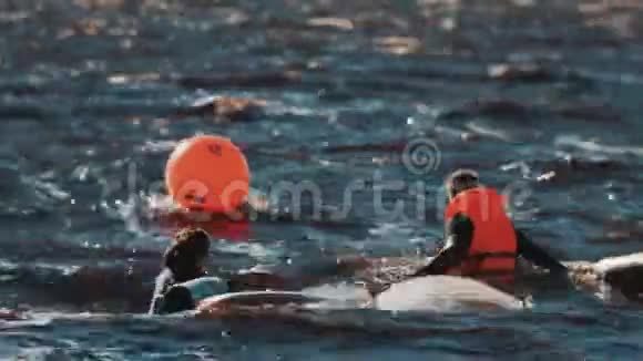 两个冲浪者漂浮在水面上靠近冲浪板和橙色信标很多浪视频的预览图