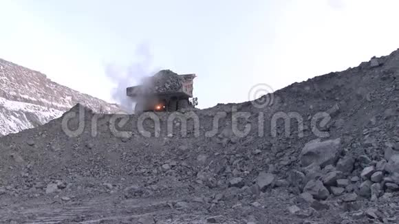 自卸卡车把矿石卸到峡谷里视频的预览图