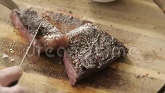 餐厅里的人拿着一把刀切了牛排烤着大理石牛肉在木板上工作牛肉牛排烹饪视频的预览图