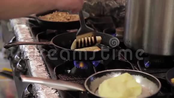 在一个热的煎锅里厨师用一个灌装的面粉信封来炸薯条视频的预览图