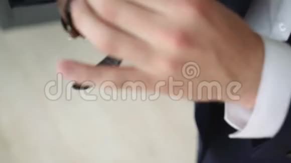 一个穿着西装的男人手里拿着手表商务人员按钮钟手在特写视频的预览图
