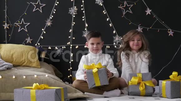 男孩和女孩扔礼物在圣诞节内部的背景下视频的预览图