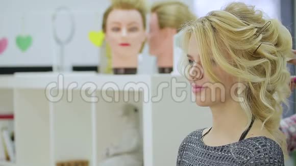 可爱的金发女孩在美容院照镜子视频的预览图