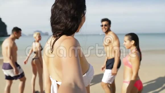 在沙滩上欢乐的人在水中奔跑的女孩快乐的男男女女视频的预览图