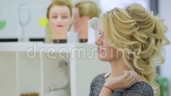 可爱的金发女孩在美容院照镜子视频的预览图
