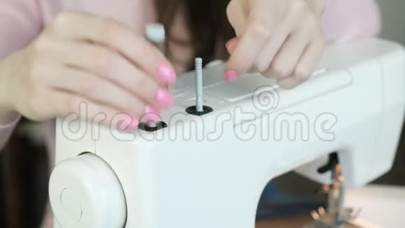 年轻女子把线轴放在缝纫机上准备工作视频的预览图