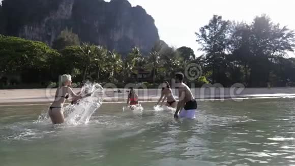 人们在水中嬉戏在山区沙滩上欢乐的青年男女群体视频的预览图