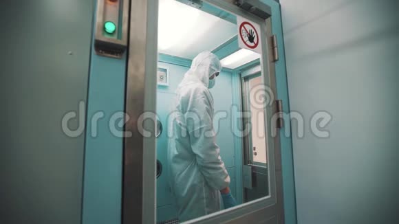 无菌衣服的科学家走出消毒室和实验室视频的预览图