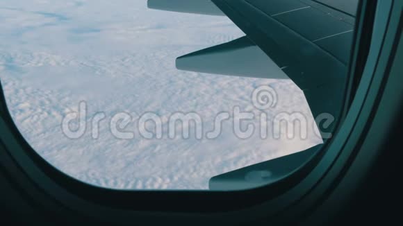 飞机的机翼穿过舷窗飞机飞过美丽的空中云层视频的预览图