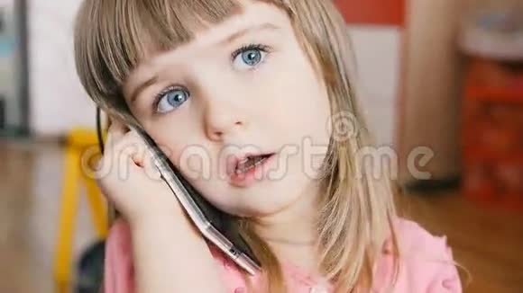 小孩子像个成年人坐在房间的地毯上在智能手机上说话视频的预览图