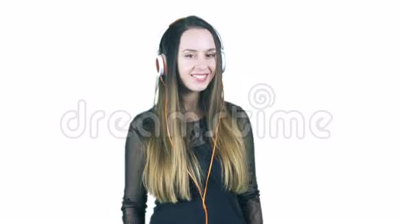 年轻女子戴着耳机听音乐微笑着回答有人问她的问题视频的预览图