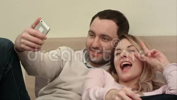 情侣们玩着玩着通过智能手机在床上自拍视频的预览图