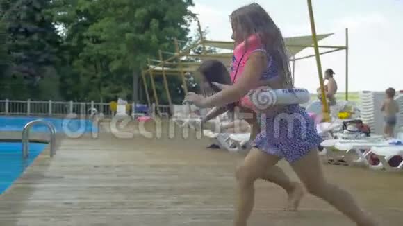 两个小女孩掉进了水上乐园的游泳池暑假视频的预览图