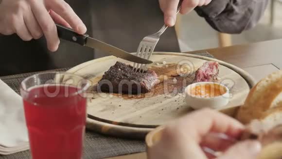 餐厅里的人拿着一把刀切了牛排烤着大理石牛肉在木板上工作牛肉牛排烹饪视频的预览图