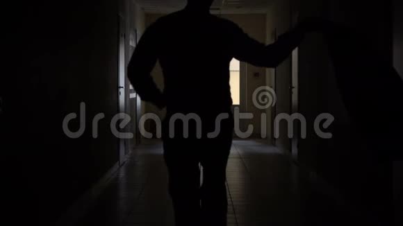 慢动作一个男人的剪影穿过黑暗的走廊开除商人的鬼视频的预览图