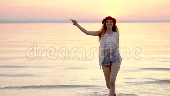 戴着帽子的年轻金发女子在金色夕阳下享受快乐的暑假视频的预览图