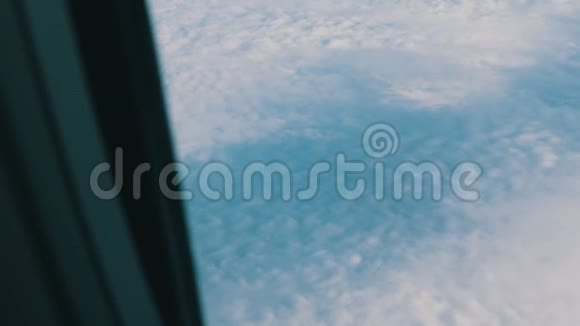 飞机的机翼穿过舷窗飞机飞过美丽的空中云层视频的预览图