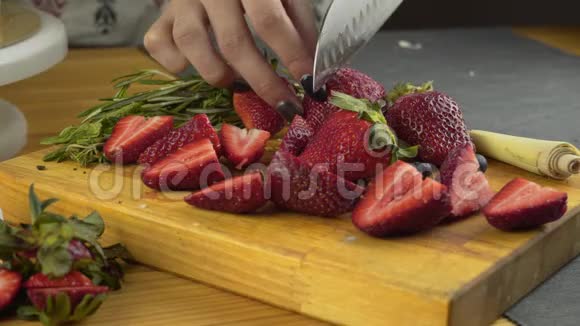 特写女性手切新鲜有机草莓女性用锋利的刀切新鲜有机草莓水果视频的预览图