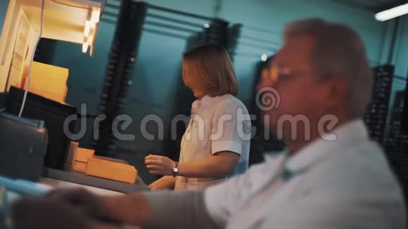 穿白袍的女人拿着桌上的塑料托盘在实验室里走开视频的预览图