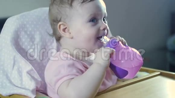 孩子坐在一张高椅子上从喂食杯里喝水视频的预览图