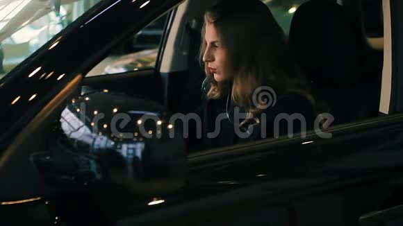 豪华轿车沙龙里的布鲁内特女士手握方向盘视频的预览图