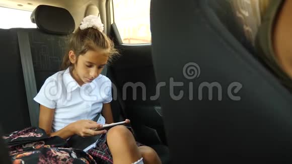 小女孩无聊的在车里透过窗户看窗外街道反射4k慢动作视频的预览图