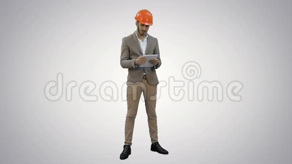 年轻经理戴着头盔拿着平板电脑在白色背景上显示拇指视频的预览图