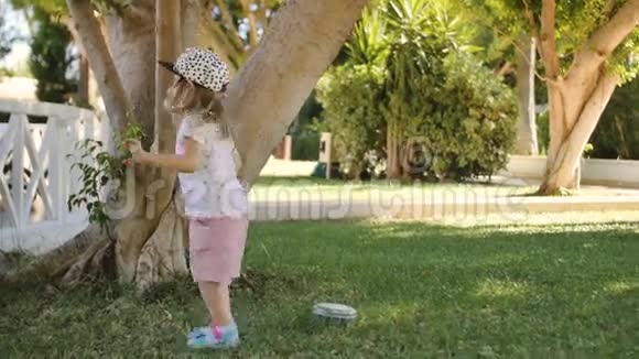 可爱的小女孩从草地上收集树枝跳起来视频的预览图