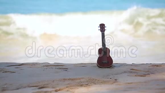 一个四弦琴夏威夷的乐器放在海滩和蓝色的大海和波浪上视频的预览图