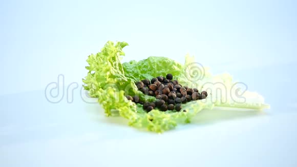 带有黑胡椒豌豆的生菜叶在白色背景上旋转视频的预览图